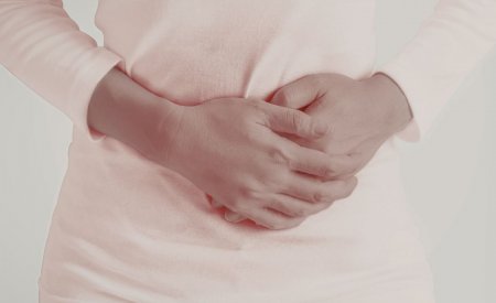 kobieta trzymająca się za brzuch
